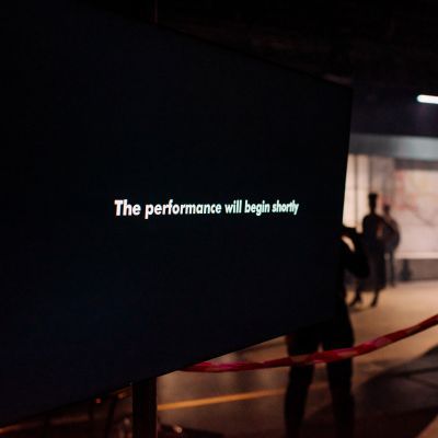 TV screen on set reading 'The performance will begin shortly' during a technical rehearsal